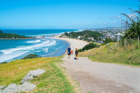 TAURANGA NEW ZEALAND- FEBRUARY 9 2019; People walking on uphill track on Mount Maunganui with scenic endless beaches stretching out to blue horizonのeditorial素材
