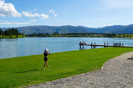 CROMWELL NEW ZEALAND - OCTOBER 21 2019; Lake Dunstan scene with young woman walking along lake edge...
