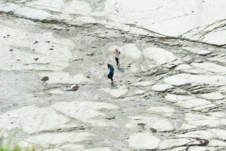 KAIKOURA NEW ZEALAND - OCTOBER 27 2018; Two young women travelers in distance, walking on flat...