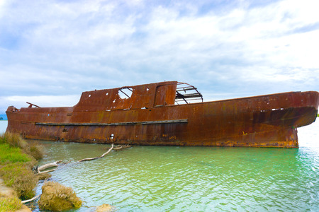 Scuttled rusting hulk of old ship Waverley in shallows of Wairau Lagoons on nature walk.の写真素材