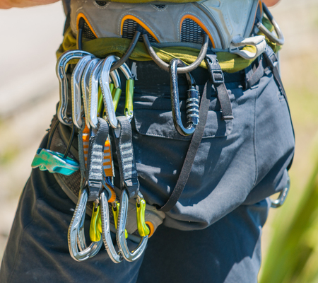 Mountaineering safety equipment hanging on harness close-up, ready to start.の写真素材
