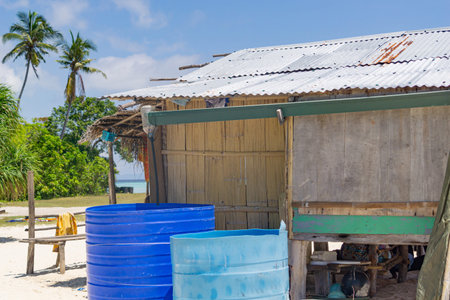 Jerry rigged rain water collection system fixed to side of frail home structure on small Pacific...