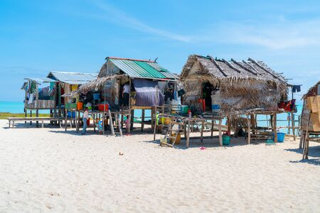 SEMPORNA BORNEO - MAY 11 2019; Small group gypsy stilt homes on small tropical island with all their posessions and children.1のeditorial素材