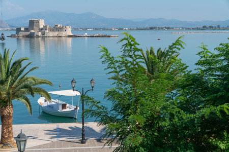 View across promenade to island Bourtzi with old fortress set in blue Mediterranean off-shore from...