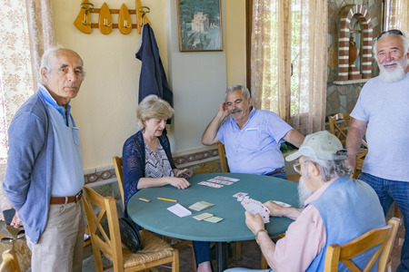 VOURGARELI - GREECE - JULY 23 2019; Elderly people playing card during day in Greek hill village bar.のeditorial素材