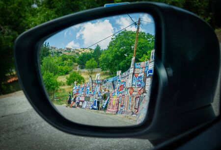 Greece - July 26 2019; Roadside display of Greek rugs for sale as driving by in rural countryside in rear vision mirrorの写真素材