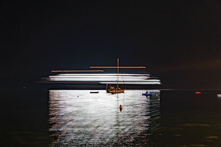 Night scenes of Skiathos harbour, light streams of passing ferry in  long exposure imageの写真素材