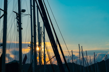 Sun bursts through masts of moored yachts in Skiathos harbor.