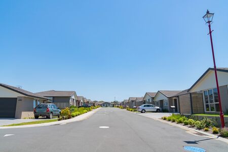 New subdivision street with uniform homes and front gardens lining both sides of street.の写真素材