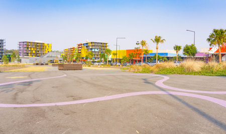 Striking multi-colored apartment and commercial buildings beyond open public space in Gold Coast...