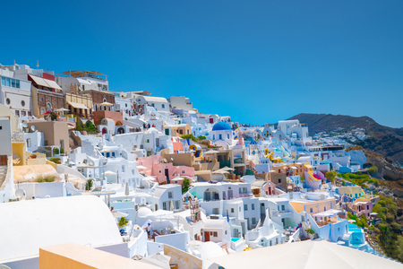 Oia, Santorini, Greece - August 7 2019; Hillside homes and buildings in whitewashed with splashes of color in traditional Greek Island style with touristsのeditorial素材