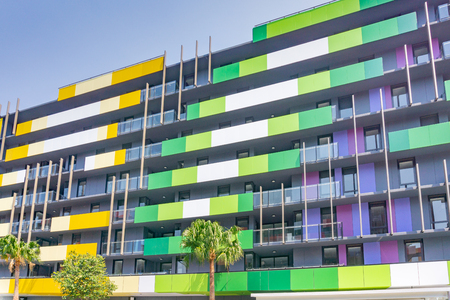 Gold Coast Australia - November 19 2019; Exterior of striking yellow and green  apartment blocks and commercial building shot from street below looking up.のeditorial素材