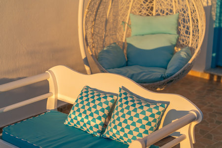 Terrace with two form of chair in golden glow of morning sun.