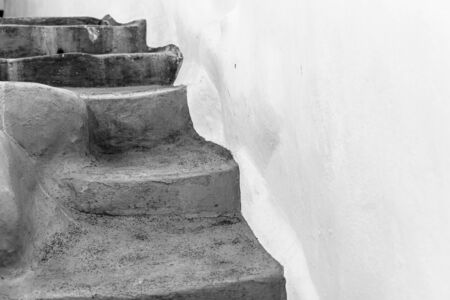 Steps against whitewashed wall where steps seem to randomly lead everywhere yet always end up at a door.の写真素材