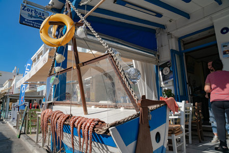 Naxos Greece - August 11 2019;  Octopus tentacles lying over side of boats outside restaurant in...