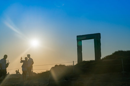 naxos Greece - August 12 2019; Temple of Apollo marble gate at top of hill and people enjoying the sunset taking selfie.のeditorial素材