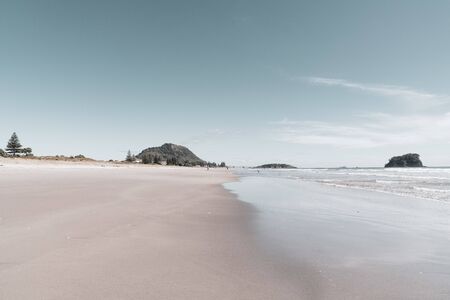 Ocean beach with Mount Maunganui at end, wide and flat sandy area in vintage effect.の写真素材