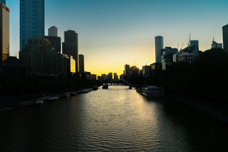 Melblourne commercial skyline on both sides of Yarra River at sunset.の写真素材