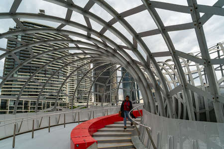 Melbourne Australia - March 13 2020; Inside Webb Bridge designed for cyslists and pedestrians to cross the Yarra River the bright red devider separates cyclist side from pedestrians.のeditorial素材