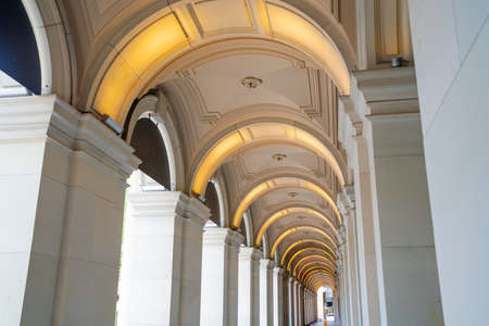 Long exterior portico of old Melbourne General Post Office Building with row of repeating illuminated arches diminishing along the building.のeditorial素材