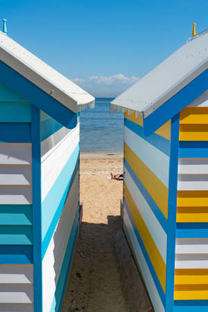 Melbourne Australia - March 11 2020; View between colourful Brighton Beach boxes to water's edgeのeditorial素材