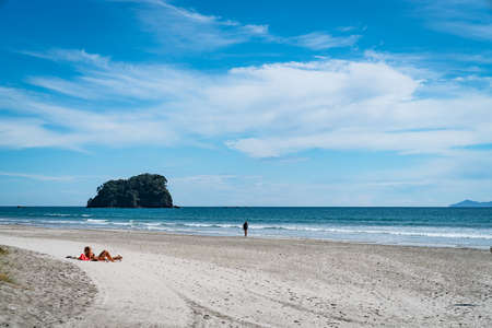 Tauranga, New Zealand - February 24 2020; Beach background image with incidental people sunbathing and walking.のeditorial素材