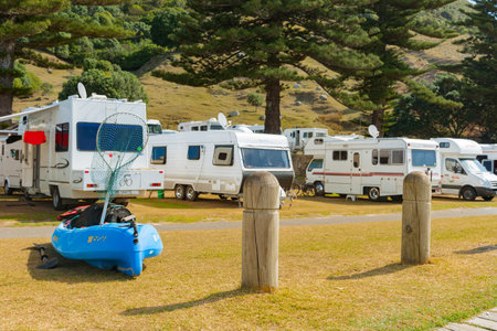 Tauranga New Zealand - April 102013; Blue kayak with fishing gear on lawn in holiday park ready to...