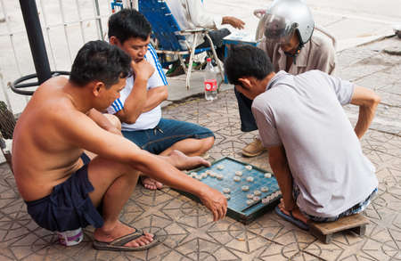 Can Tho Vietnam - October 15 2013; Four men playing checkers on urban footpath is a typical scene in Asian cities.のeditorial素材