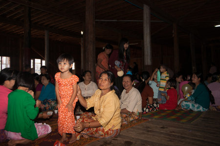 Myanmar - November 3 2013; GAthering of women and children in village hall for an event.のeditorial素材