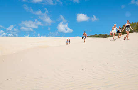 Fraser Island Australia - March 13 2014; Tourists walking through sand of Lake Wabby sand blowのeditorial素材