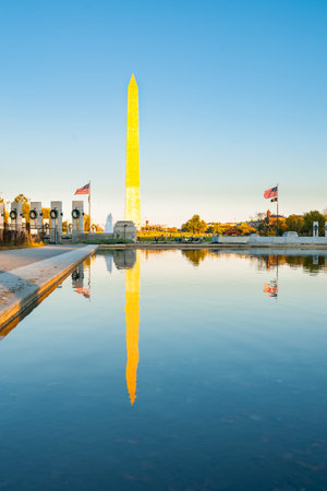 Washington DC USA - October 26 2014; George Washington Memorial obelisk standing proud catching golden rays of sun reflected in calm Reflecting Pool.のeditorial素材