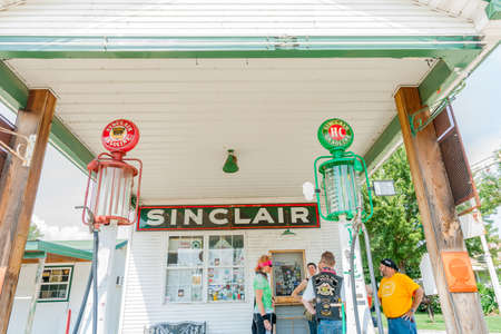 Springfield USA - September 6 2015; Four bikers standing talking in forecourt of historic Gay Parita Sinclair service station.のeditorial素材