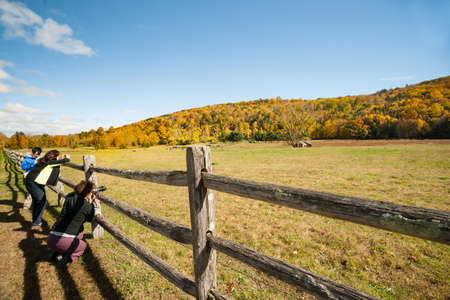 Kent USA - October 20 2014; Three tourists stop on American country road to photgraph a small landscape with red shed in distance under a tree in Kent county, New England United States of America.のeditorial素材