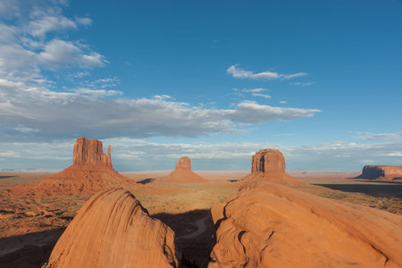 Monument Valley landscape of imposing structures of geological rock outcrops spread to horizon in...