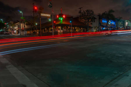 Manhattan Beach USA - October 6 2015; village at night with illuminated signs on  buildings  and car light trails in long exposure street scene in Californiaのeditorial素材