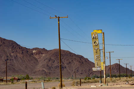 Henning USA - October 2 2015; Old motel sign along highway on part Route 66 standing among parallel lines of low mountain range and power polesのeditorial素材