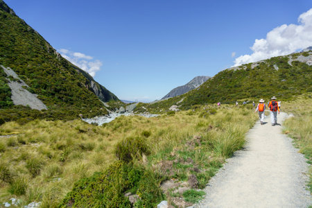 Mount Cook New Zealand - Febuary 16 2015; Hooker Valley track with tourists on one of great walks winding through alpine vegetation between mountain slopes with tourists enjoying the walkのeditorial素材