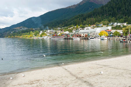 Queenstown New Zealand - March 1 2015; View across lake to tourist waterfront with its piers and buildings.のeditorial素材