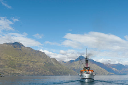 Queenstown New Zealand - March 1 2015; TSS Earnslaw tourist passenger classic steamship cruising with scenic mountain background.のeditorial素材