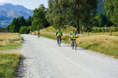 South Island New Zealand - March 5 2015; Travellers cycling along old rural dusty roadのeditorial素材