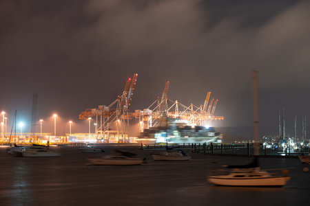 Nicght scnes of Port of Tauranga wharves at night with  bllurred moving ships, boats and container...
