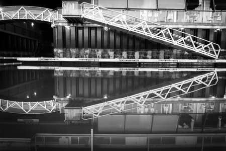 Calm water picks up pier access and apartment reflections in monochrome.の写真素材