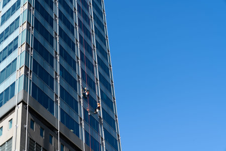 Wellington New Zealand - July 28 2021; Blue sky and glass facade of high-rise building with window...