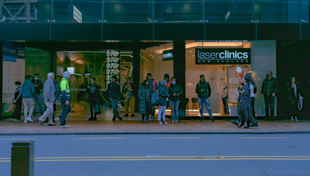 Wellington New Zealand - July 30 2021; People wait for transport and walk past on pavement across...