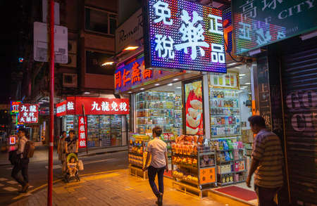 Kowloon Hong Kong - August 3 2017; Night time on city street with brightly lit shops and signs in Chinese characters and shoppers on street.のeditorial素材