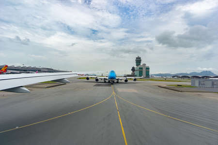 Chek Lap Kok Hong Kong - August 3 2017; Planes and runway markings leading from plane on airport runway at international airportのeditorial素材