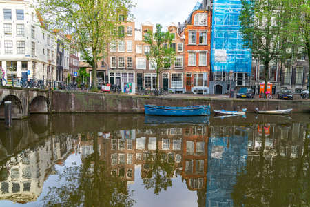 Amsterdam Holland - August 19 2017; Blue boat named Capital Value moored along canal side with buildings reflectedのeditorial素材