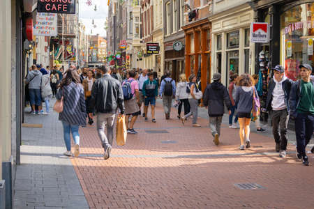 Amsterdam-Netherlands - August 21 2017; People walking in typically European street street lined with retail shopsのeditorial素材