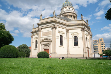 Berlin, Germany - September 25, 2017: Traditional style building with brass dome and gold statue and young woman lying on lawn.のeditorial素材