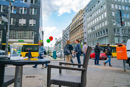 Berlin, Germany - September 25, 2017: Cafe tables and chairs on pavement in street with people passing and crossing.のeditorial素材